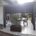 Pergola bioclimatique alu anthracite 10,80m² toit avec lames ovales alu + 5 panneaux moucharabieh + 1 rideau gris – HABRITA
